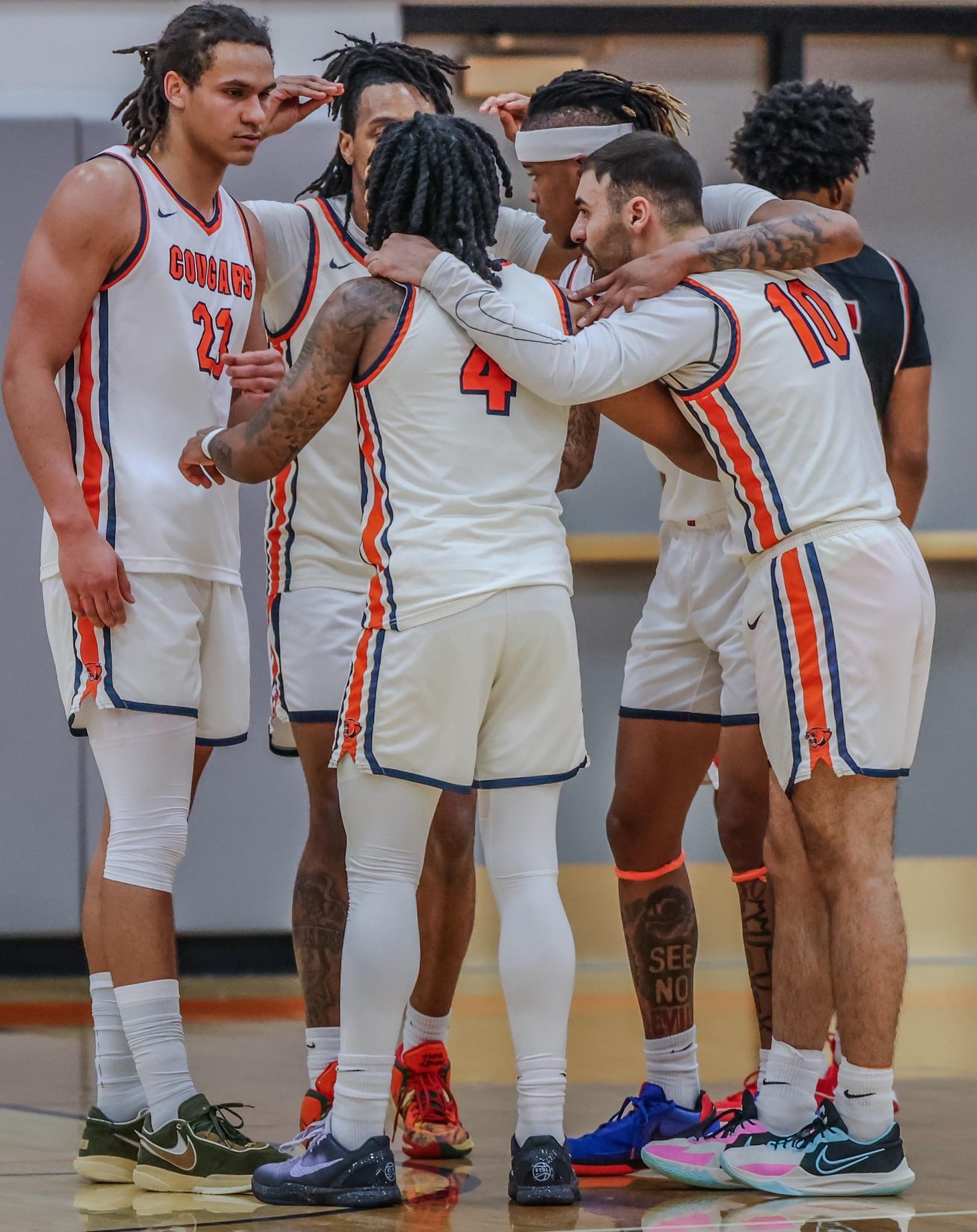 Basketball players gathered in a team huddle during competition
